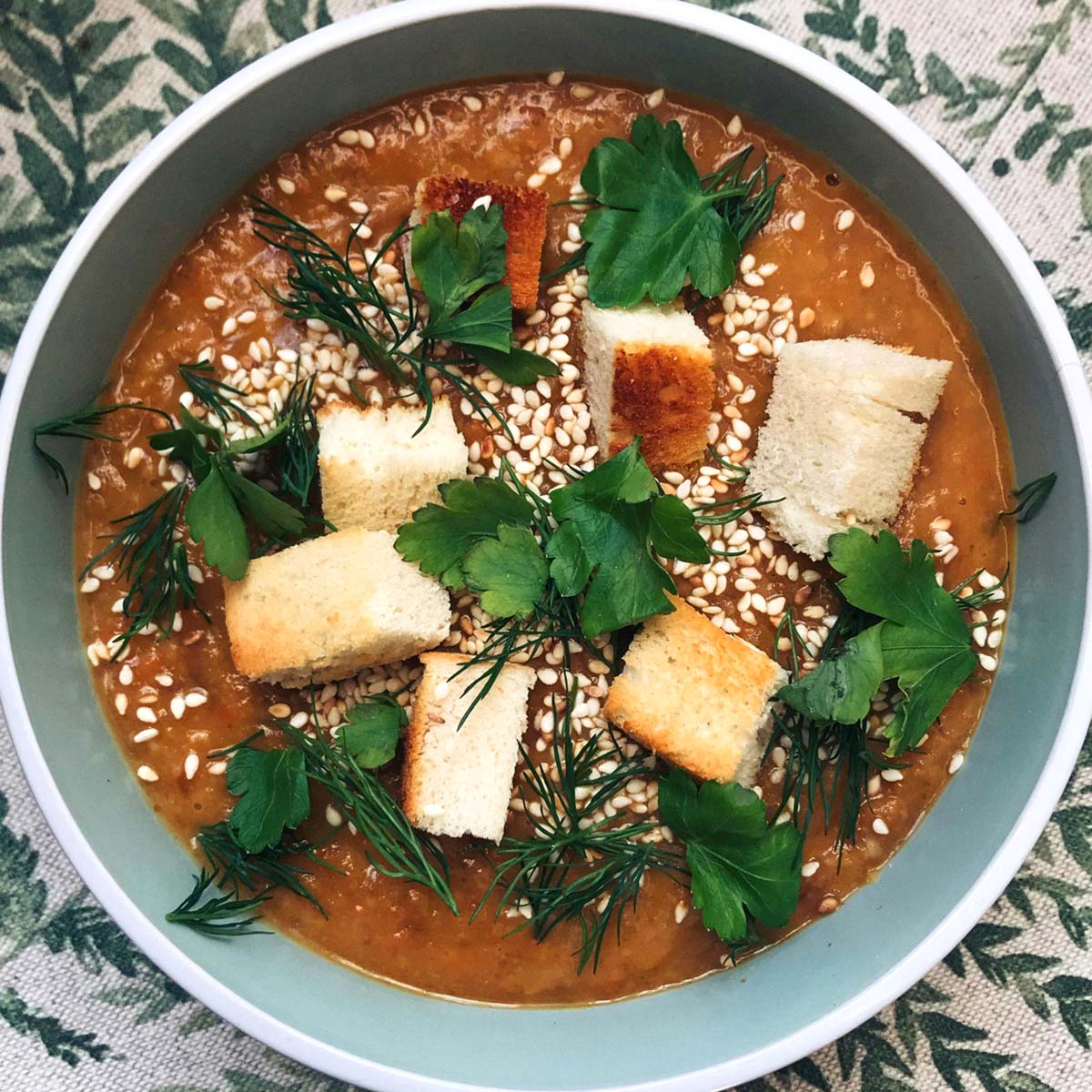 Recettes de poulet des bois Un bol de soupe garni de croûtons, de graines de sésame et d'herbes fraîches.
