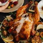 Kalkun matang yang diberi taburan rempah dan lemon, siap disajikan.