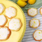 Kue gula dengan taburan lemon di atas piring kuning dengan lemon segar di latar belakang.