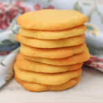 Una pila de galletas de azúcar doradas sobre un paño floral.