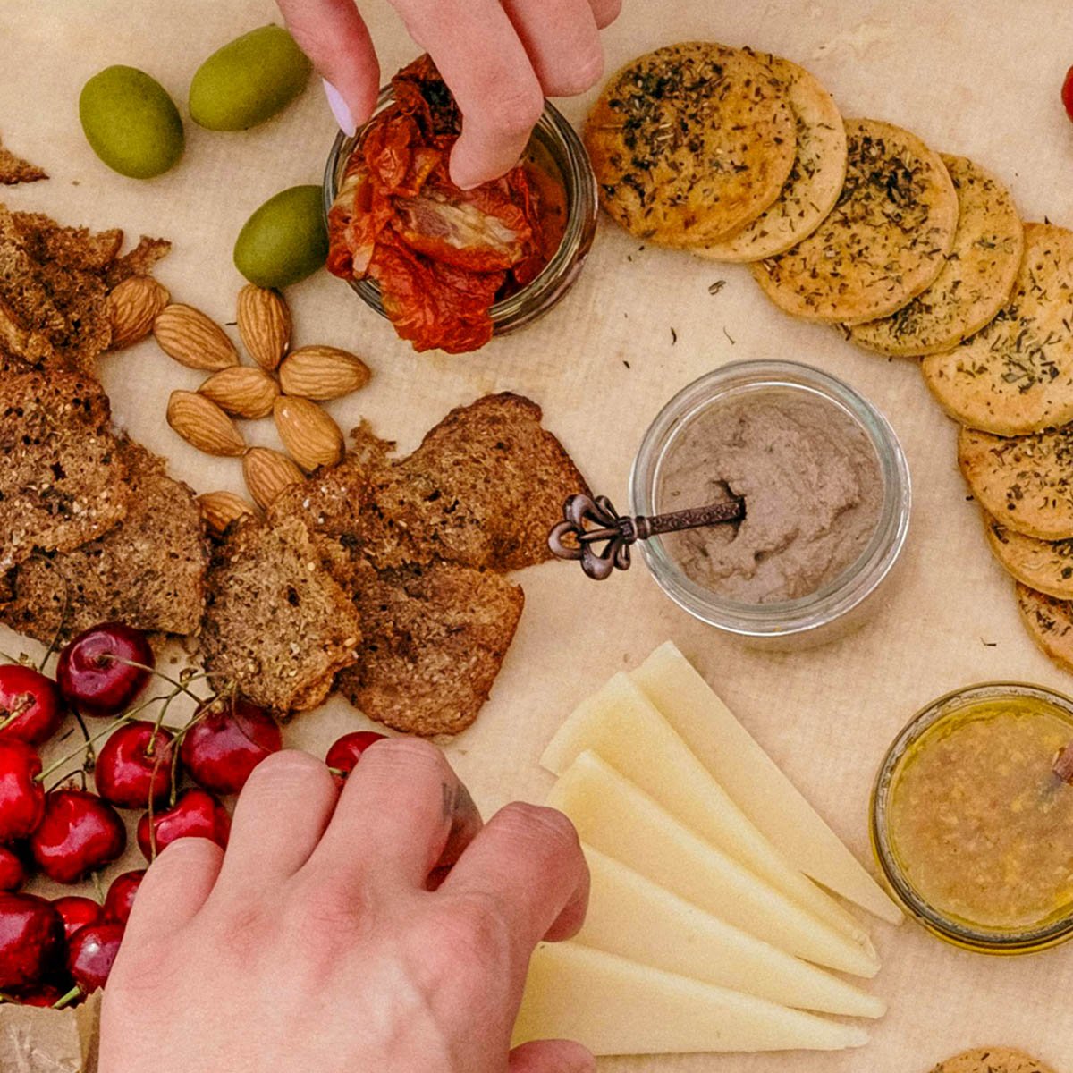 Tapenade on a board with a selection of crackers and cheeses
