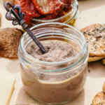 Tapenade de aceitunas en un pequeño frasco de vidrio con una cucharita