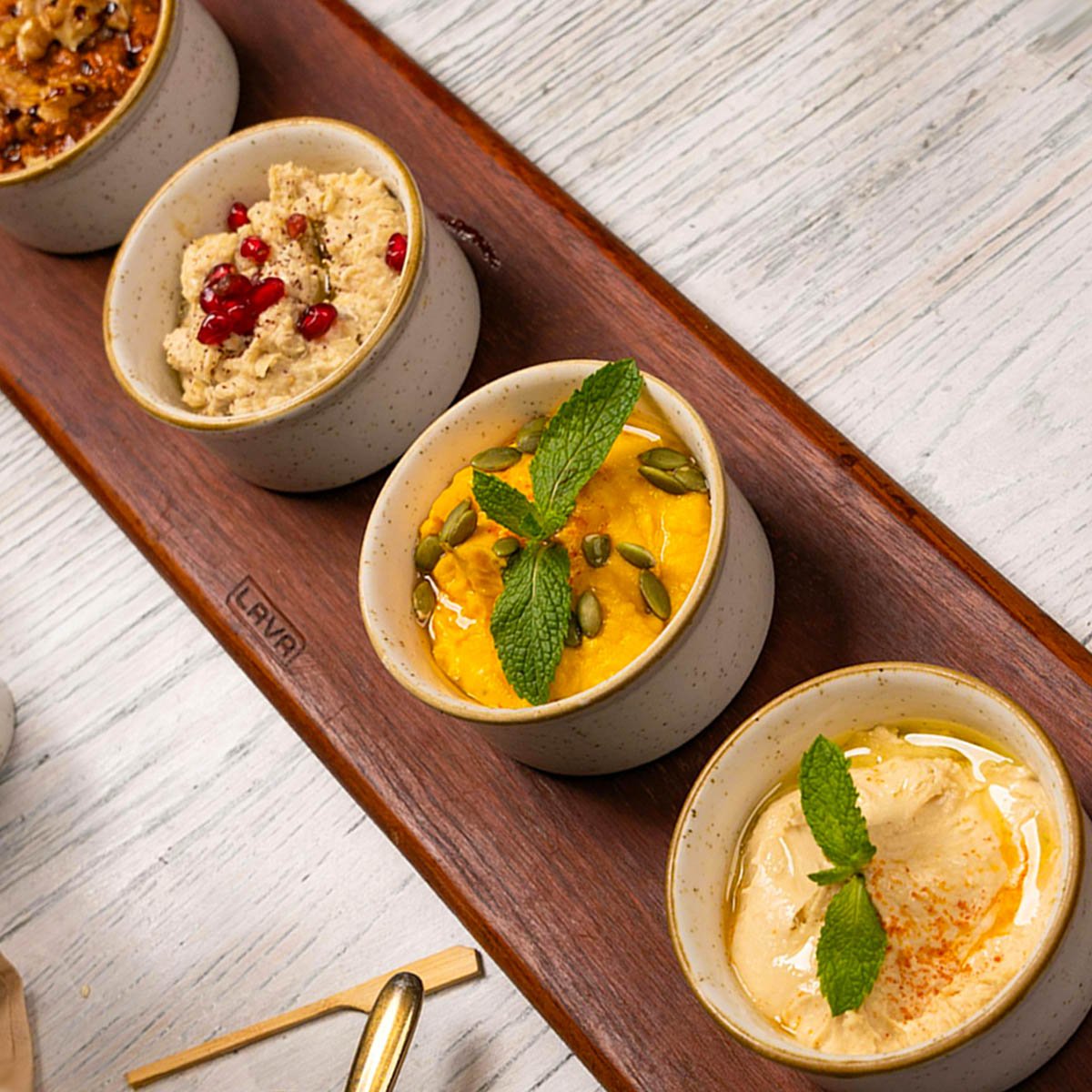 Selection of tapenades on a wooden serving board