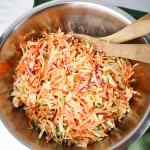 Coleslaw dalam mangkuk besar dengan sendok kayu untuk mencampur salad