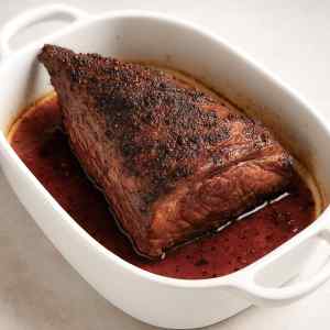 Tri tip beef also known as bottom sirloin roasted in a white roasting dish