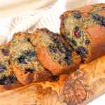 Irisan roti pisang blueberry di atas talenan kayu.