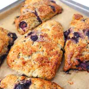 Frisch gebackene Blaubeer-Scones mit goldener Kruste auf einem Backblech.