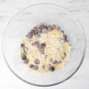 Eine Schüssel Scone-Teig, gemischt mit frischen Blaubeeren und Mehl.