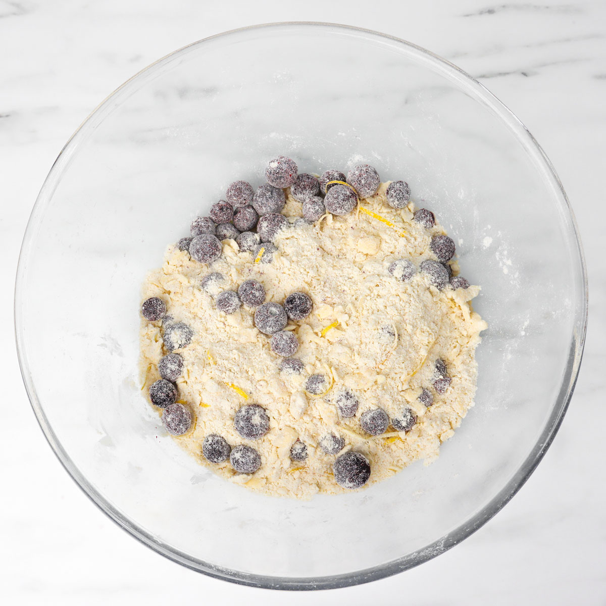 Eine Schüssel Scone-Teig, gemischt mit frischen Blaubeeren und Mehl.