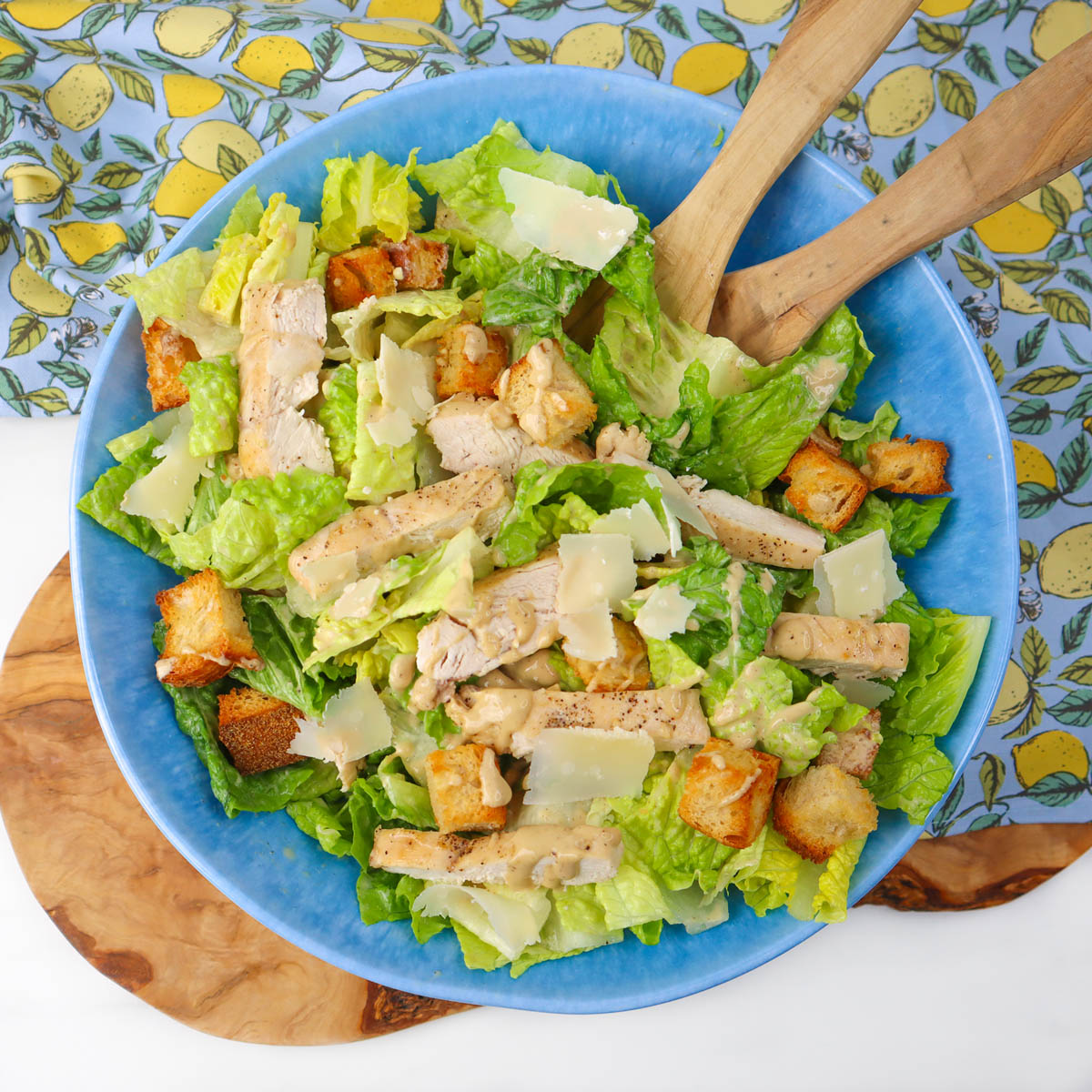 Salade César au poulet Une salade César au poulet colorée, composée de laitue romaine, de poulet grillé, de croûtons et de parmesan, servie dans un bol bleu.