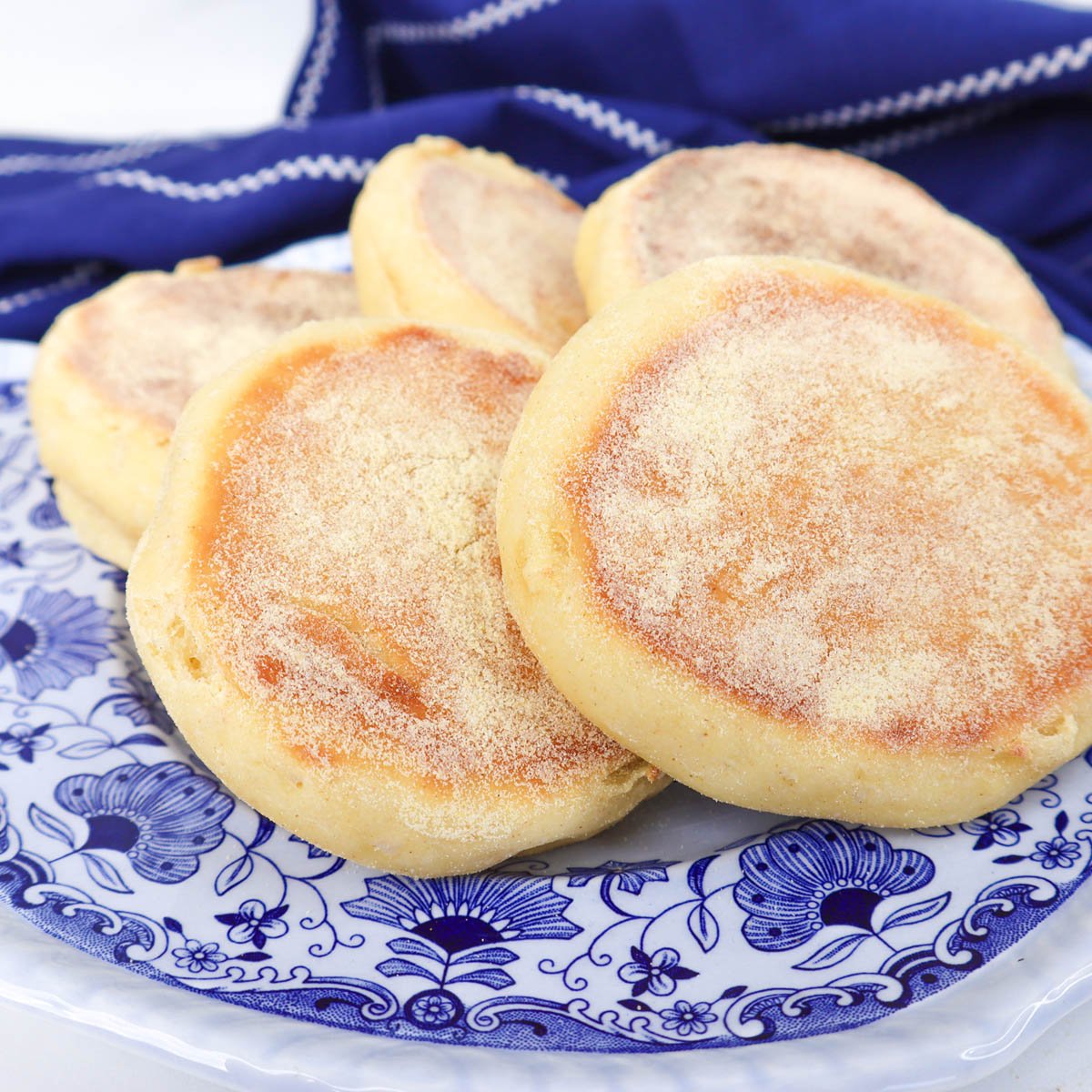 Muffins anglais fraîchement sortis du four, présentés sur une assiette décorative.