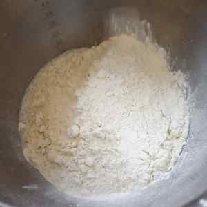 Un bol rempli de farine, prêt pour la préparation de muffins anglais.