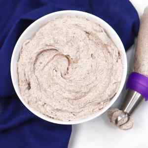 Semangkuk krim mentega Oreo yang lembut dengan kantong semprot di sampingnya.