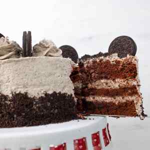 Sepotong kue Oreo yang memperlihatkan lapisan kue coklat dan krim, diberi potongan kue Oreo di atasnya.