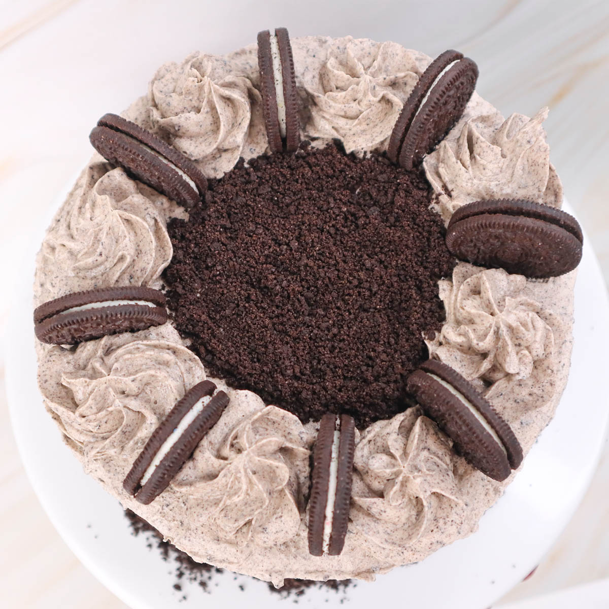 Kue Oreo berbentuk bulat dengan krim di atasnya dan remahan biskuit Oreo.