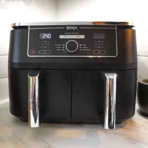 Gros plan sur le panneau de commande d'une friteuse à air Ninja, avec affichage numérique et boutons.