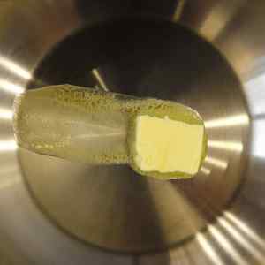 Un morceau de beurre qui fond dans une poêle en acier inoxydable.