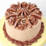 Kue coklat yang dihias dengan lapisan coklat, irisan jeruk, dan taburan warna-warni.