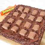 Tampilan dekat dari brownies renyah yang diberi coklat dan potongan permen toffee.