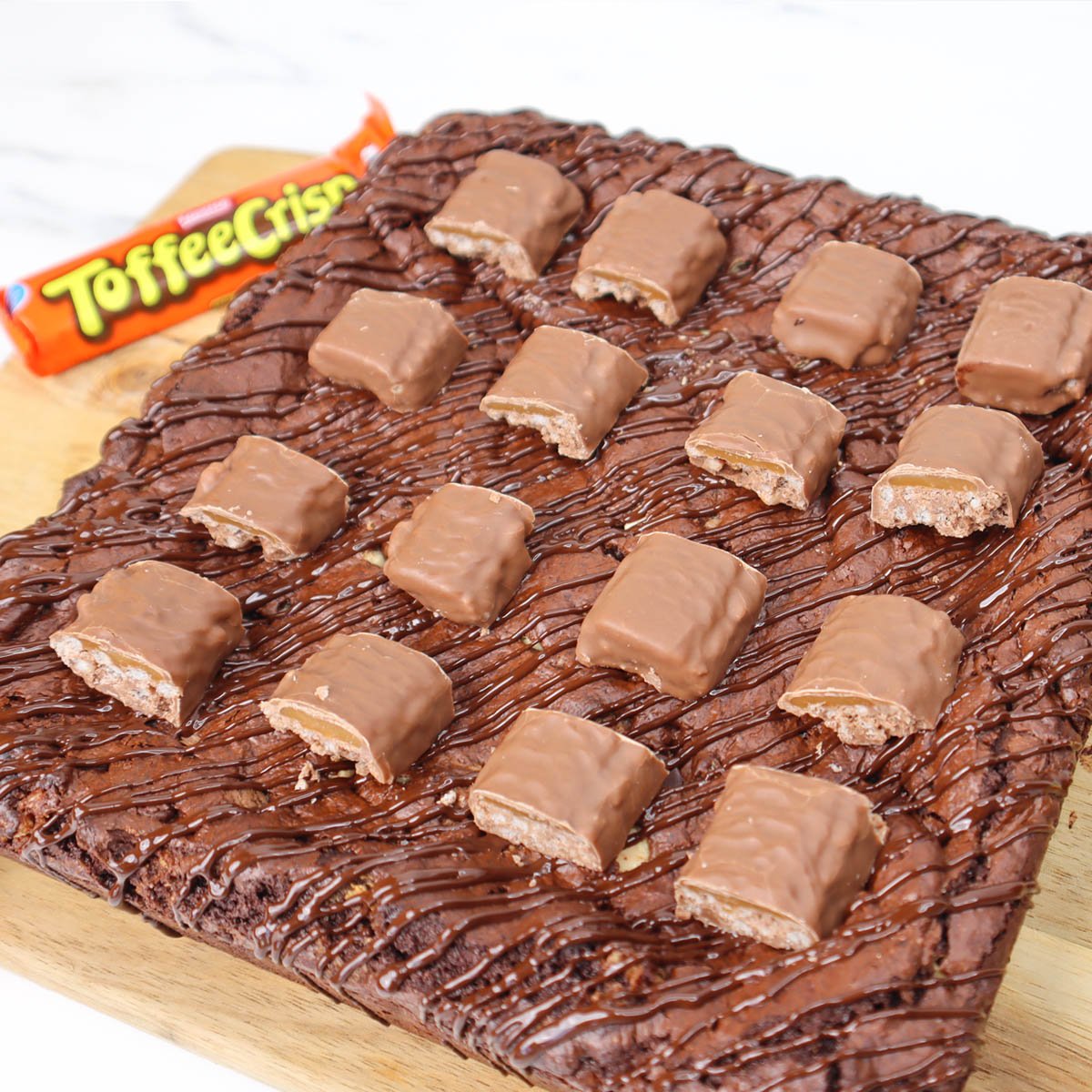 Gros plan sur des brownies croustillants au caramel, nappés de chocolat et de morceaux de caramel.