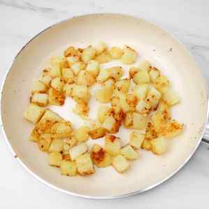 Pommes de terre coupées en dés et bien dorées, cuites à la poêle, prêtes pour les tacos du petit-déjeuner.
