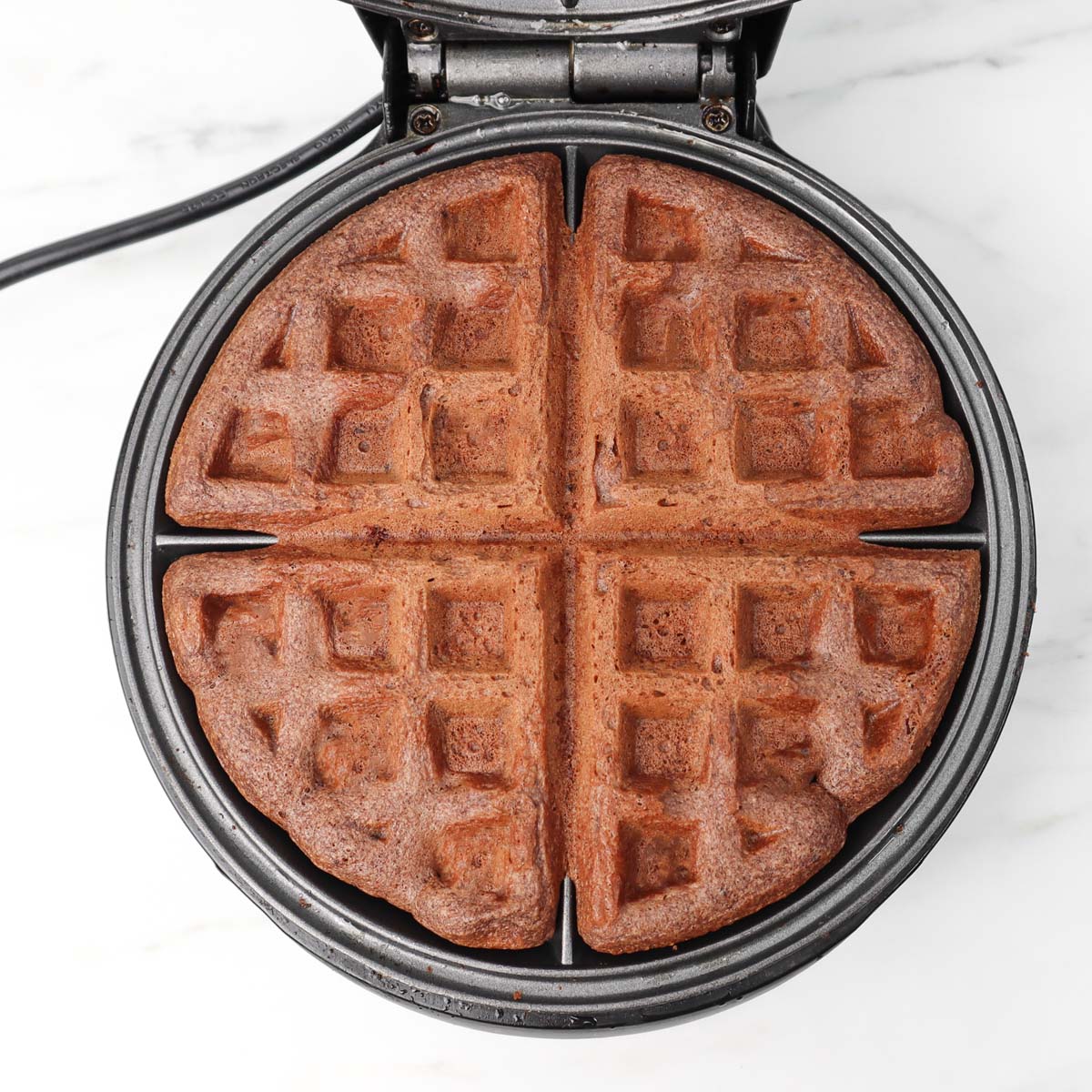 Gaufres au chocolat Gaufres au chocolat fraîchement préparées dans un gaufrier.