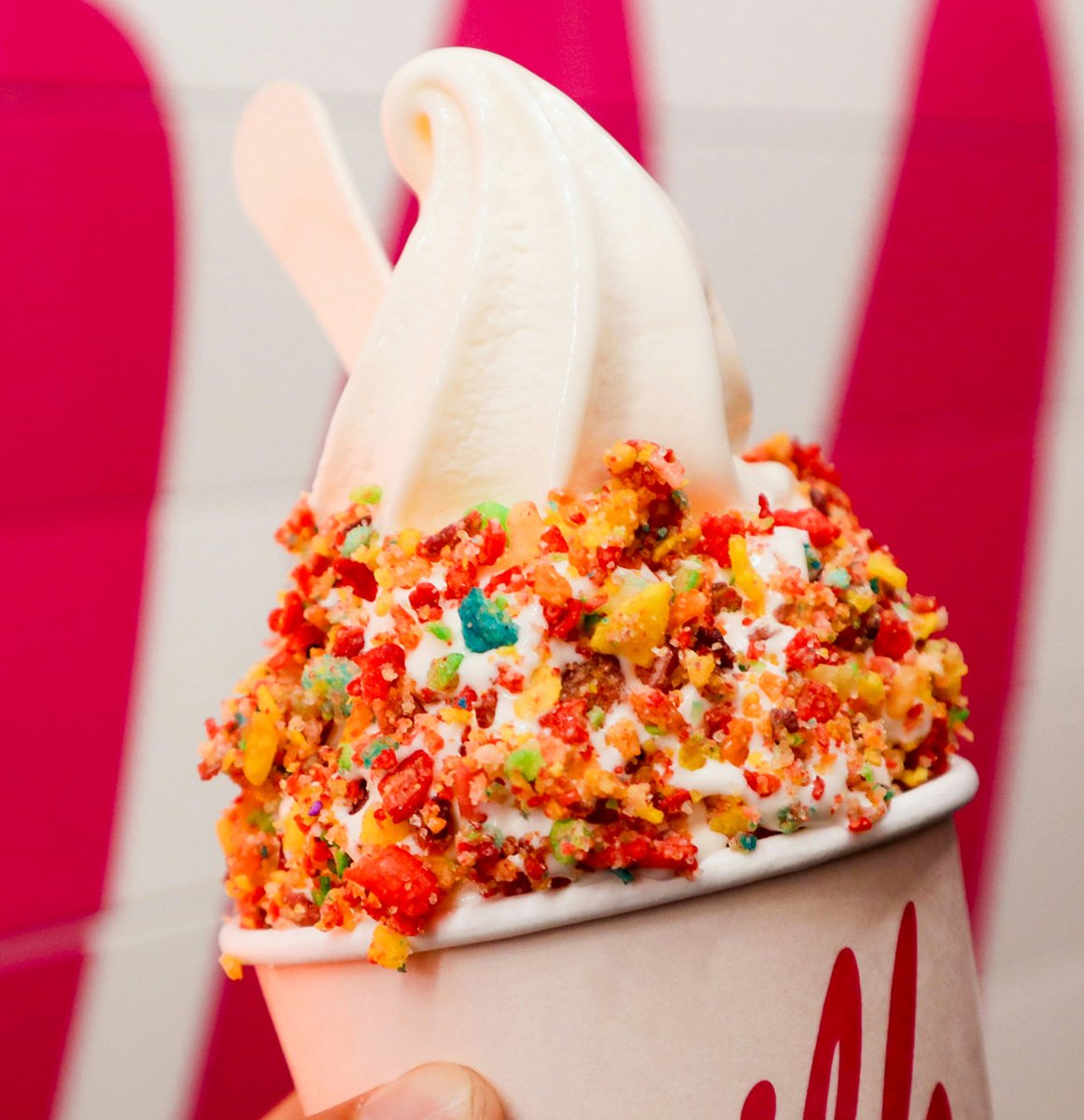 Frozen-yogurt-1200-01 A cup of frozen yogurt topped with colorful sprinkles and two spoons.