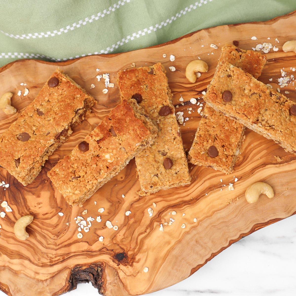 Barres de granola Barres de granola maison aux pépites de chocolat, servies sur une planche en bois.