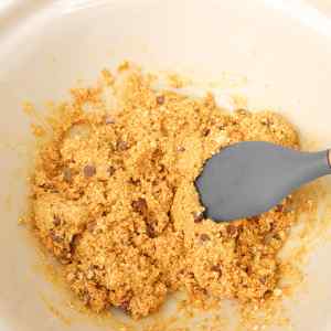 Un mélange d'ingrédients pour granola avec des pépites de chocolat dans un bol.