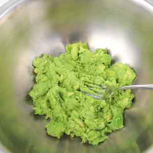 Un bol d'avocat écrasé, prêt pour la préparation du guacamole.