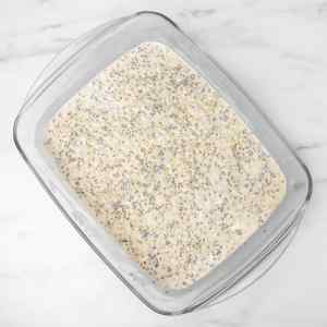 Um recipiente de vidro cheio de aveia preparada durante a noite com creme de limão, misturada com sementes de chia e aveia.