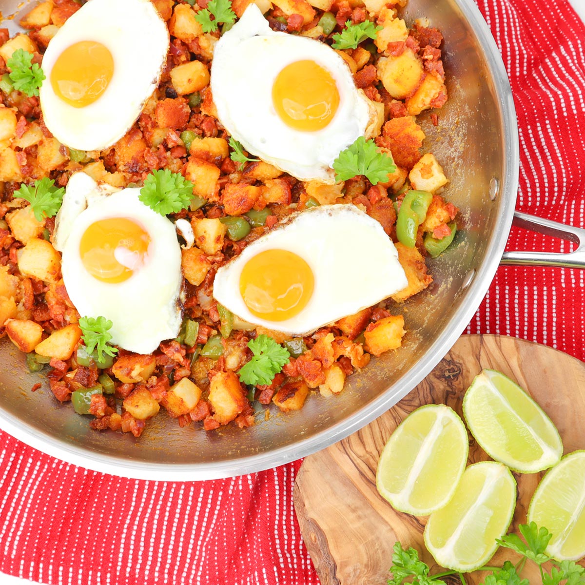 Potato and Chorizo Hash A skillet filled with potato and chorizo hash topped with fried eggs and garnished with cilantro.