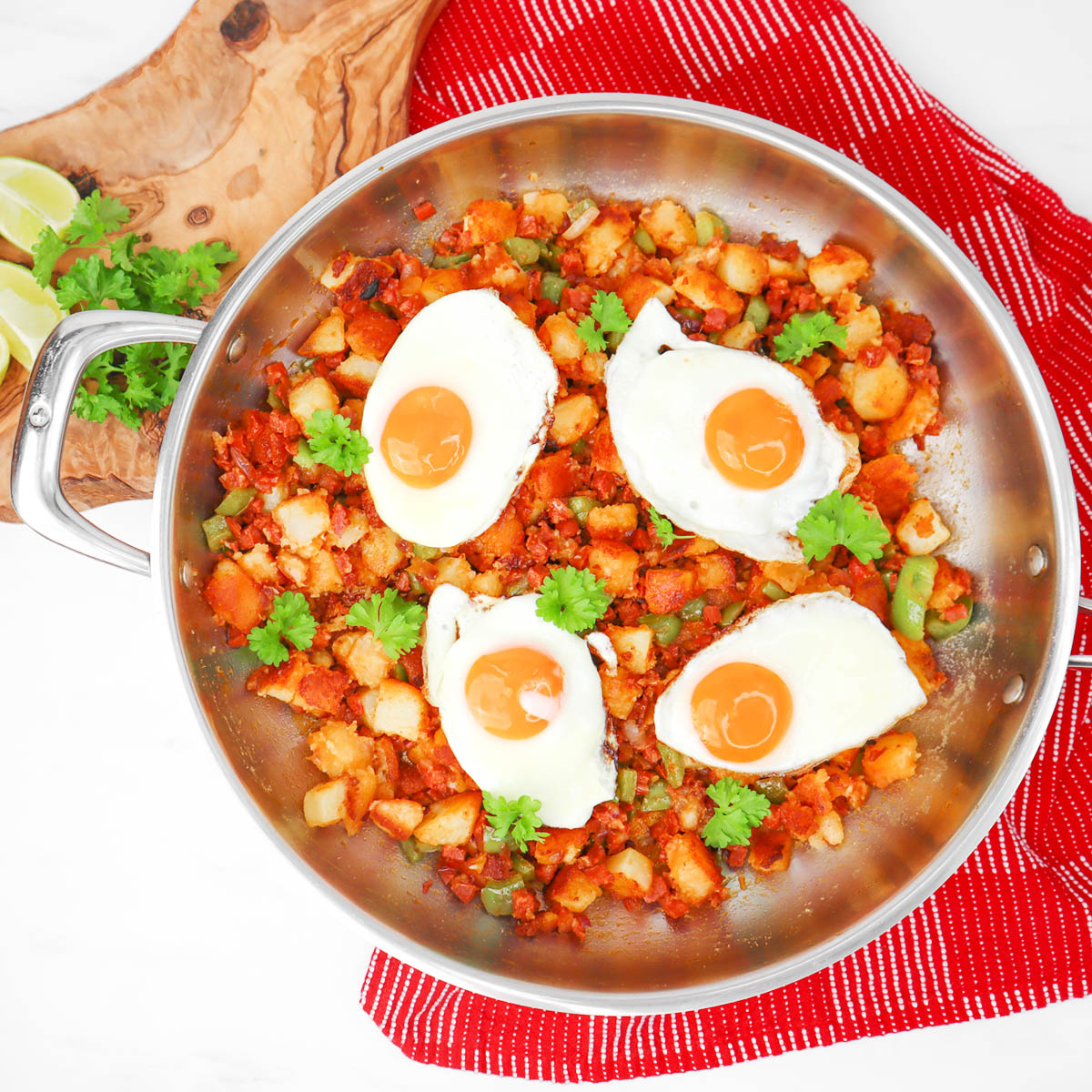 Potato and Chorizo Hash A skillet filled with potato and chorizo hash topped with fried eggs and fresh cilantro.