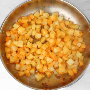 Golden and crispy diced potatoes in a skillet, ready for a hearty hash.
