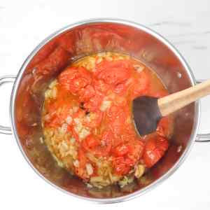 Une marmite de soupe aux tomates avec des tomates et des oignons cuits, prête à être mixée.