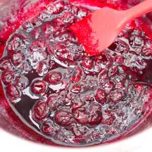 A close-up of blueberry compote with a spatula mixing it.