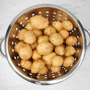 A colander filled with fresh new potatoes.
