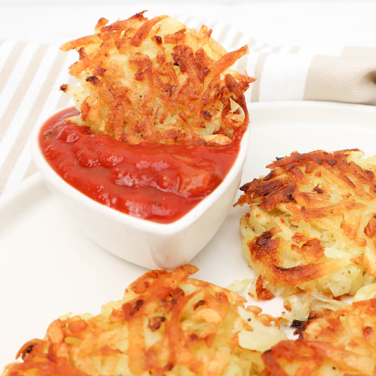 Hash Browns Crispy hash browns served with a side of dipping sauce.