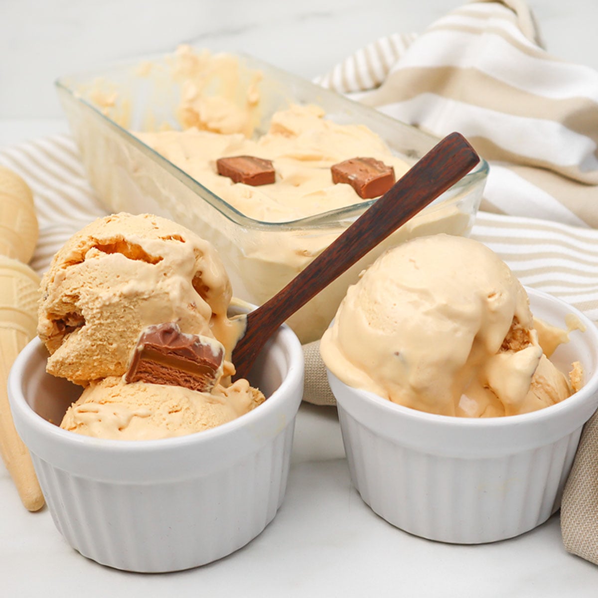 Sorvete Mars Duas tigelas de sorvete cremoso Mars com pedaços, ao lado de um prato de sorvete.