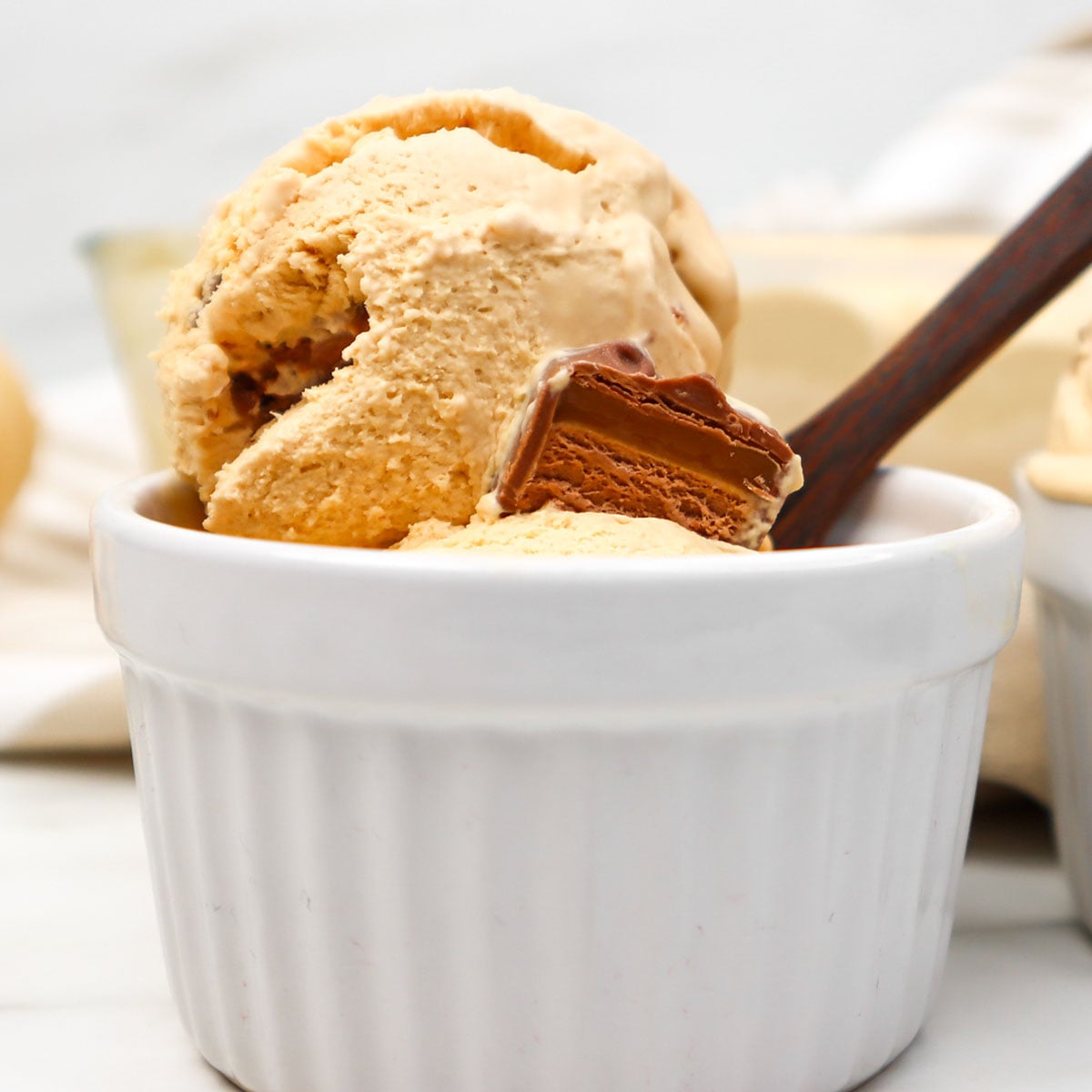 Sorvete Mars Um close-up de uma bola de sorvete cremoso com pedaços de barra de chocolate Mars em um ramequim branco.