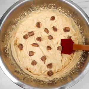 Mistura cremosa com pedaços de barras de chocolate Mars em uma tigela.