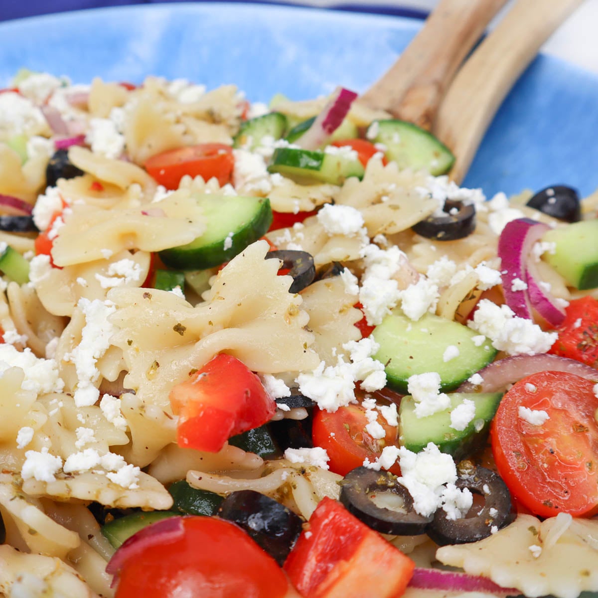 Mediterranean Pasta Salad A close-up of Mediterranean pasta salad with farfalle, cucumbers, tomatoes, olives, and feta cheese.