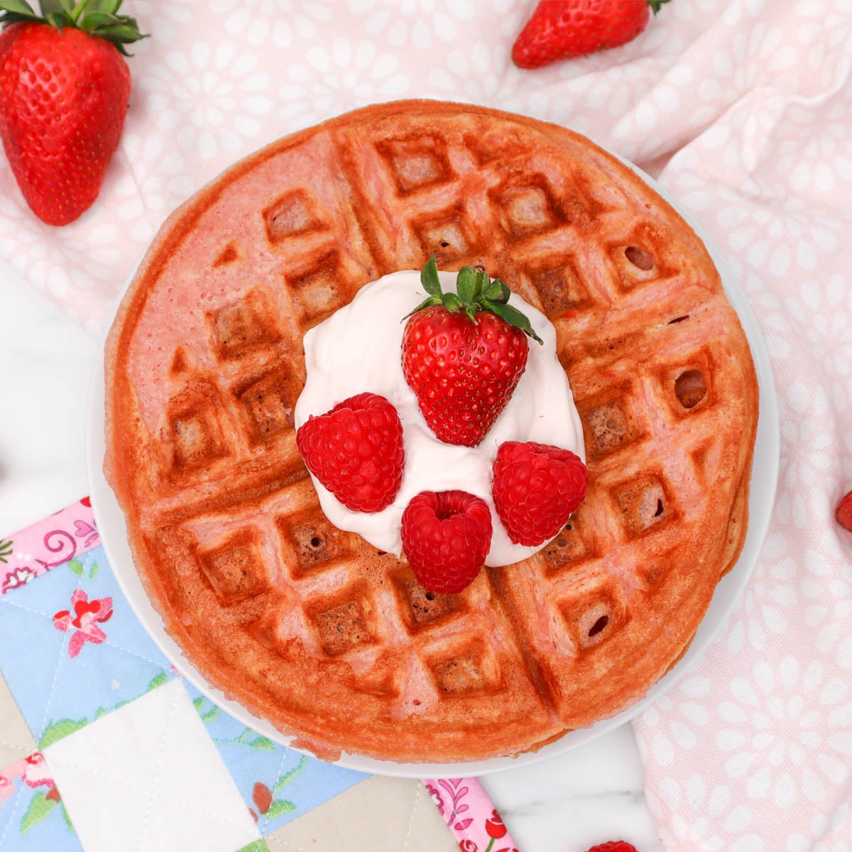 Pink Breakfast Waffles A pink waffle topped with whipped cream and fresh strawberries and raspberries.