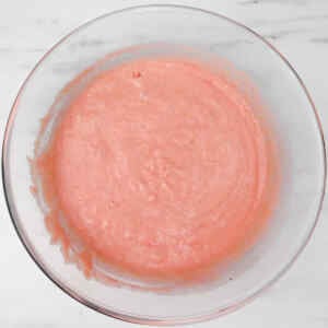 A bowl of pink waffle batter ready for cooking.