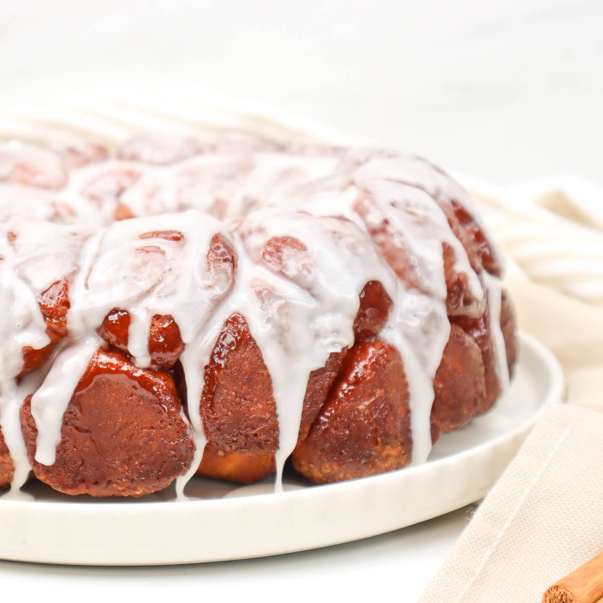 Pull Apart Monkey Bread Close-up of pull-apart monkey bread drizzled with icing on a white plate.