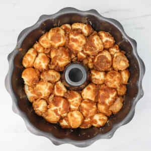 Golden brown pull-apart monkey bread in a bundt pan, showcasing its fluffy texture and sugary topping.