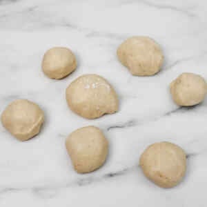 Dough balls prepared for making pull-apart monkey bread on a marble surface.