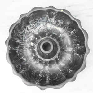 A greased bundt pan ready for baking monkey bread.