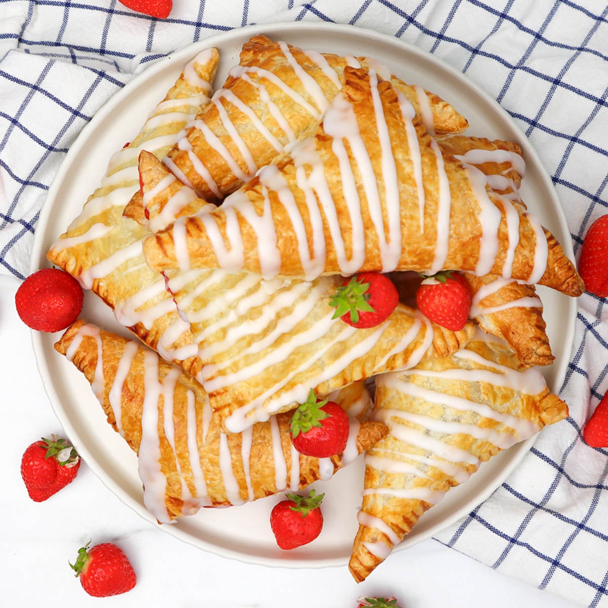 Kue Pai Stroberi Sepiring kue pai stroberi berwarna cokelat keemasan yang disiram dengan lapisan gula dan dihiasi dengan stroberi segar.