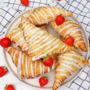 Kue pai stroberi berwarna cokelat keemasan yang disiram dengan lapisan gula dan dihiasi dengan stroberi segar.
